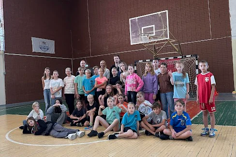 Skolas basketbola komanda. Fonā skolas sporta zāle.